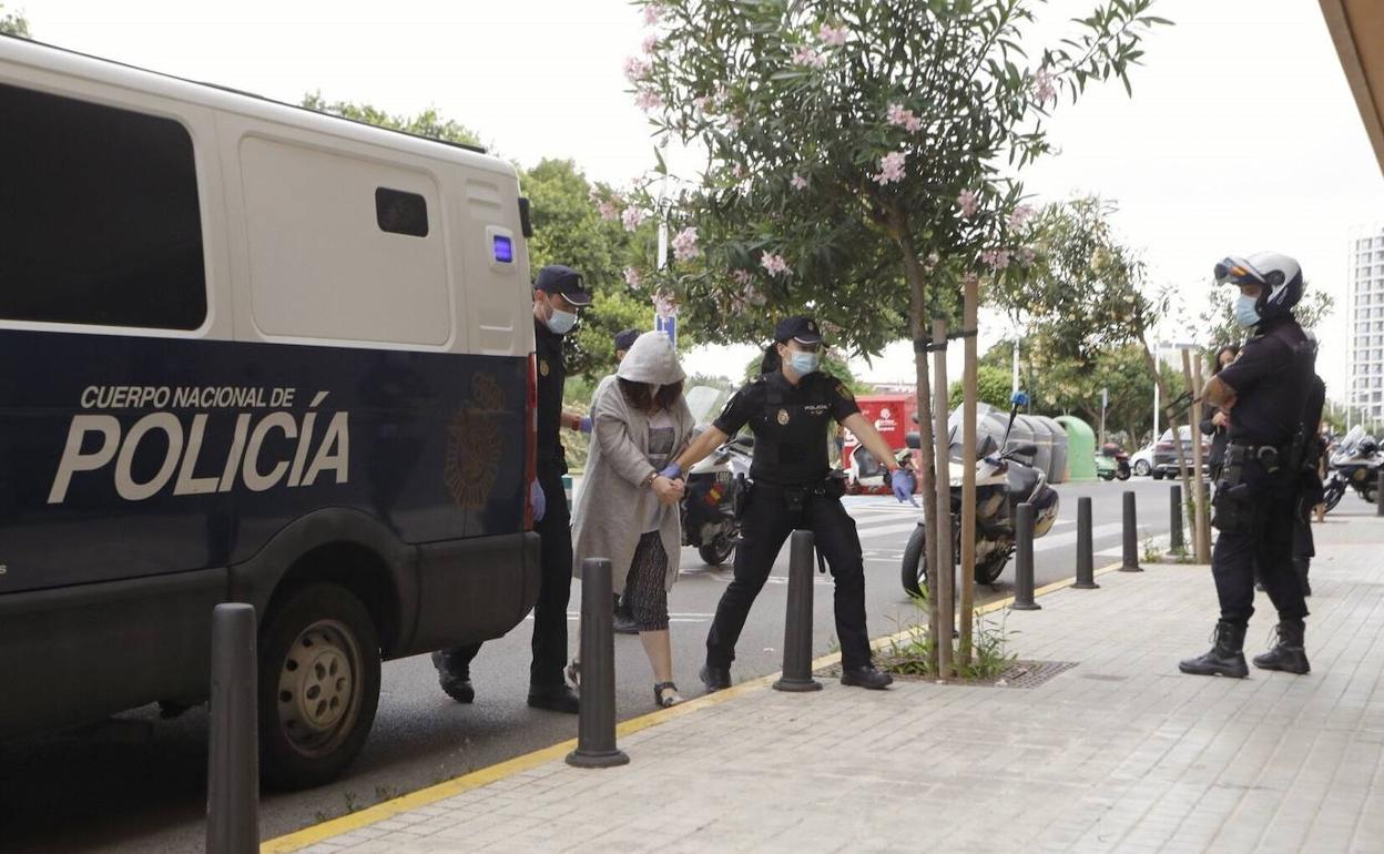 Beatriz F. C. se oculta tras la capucha de su abrigo mientras dos policías nacionales la trasladan a los juzgados de Mislata. 