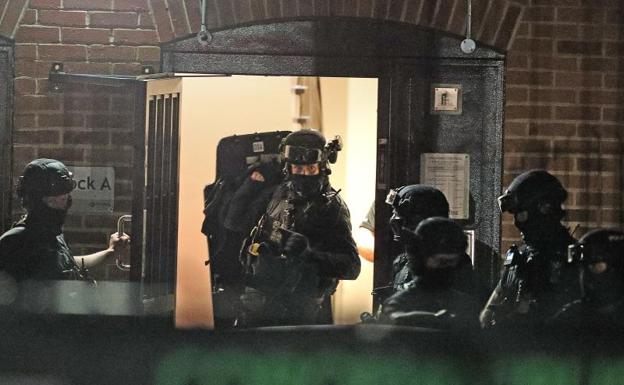 Policías entrando hacia las once de la noche en un edificio de pisos en Basingstoke Road. 