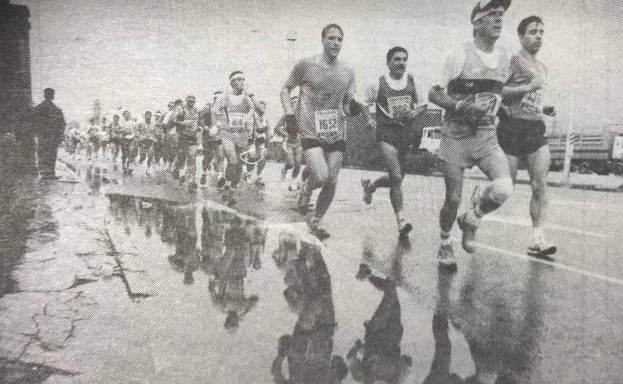 Corredores pasan junto a un charco durante una edición que ha pasado a la historia por las fuertes lluvias que la presidieron. 