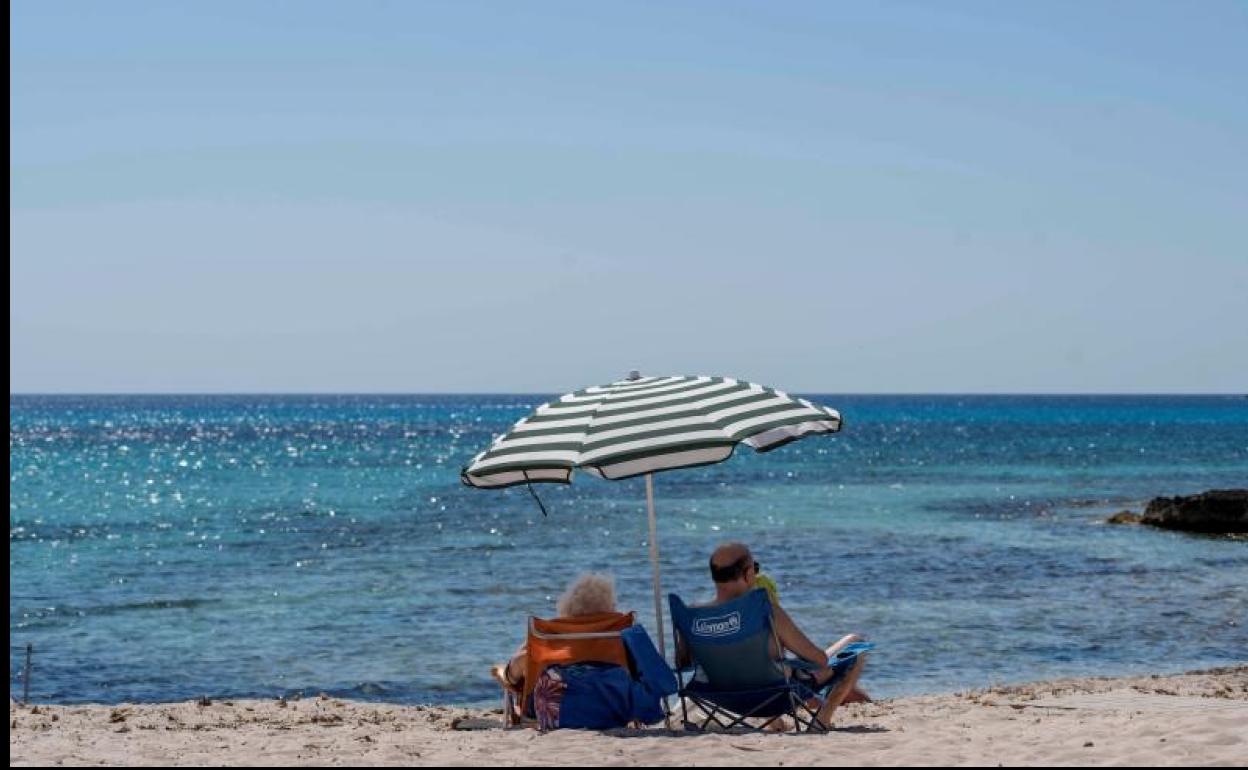 Dos personas disfrutan del buen tiempo en la playa.