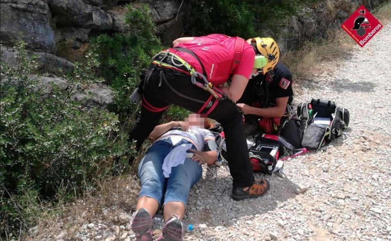 Dos bomberos atienden a la mujer. 