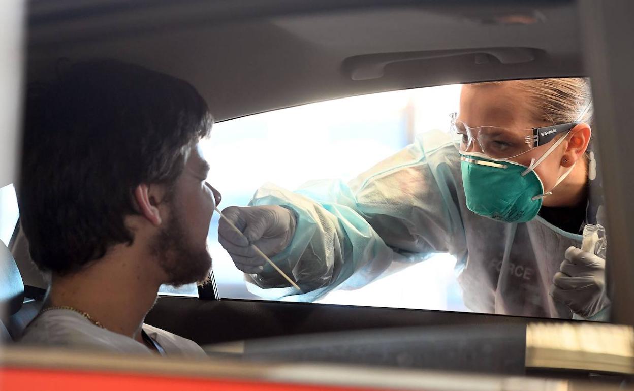 Un sanitario realiza un test a un trabajador antes de acceder a su puesto de trabajo.