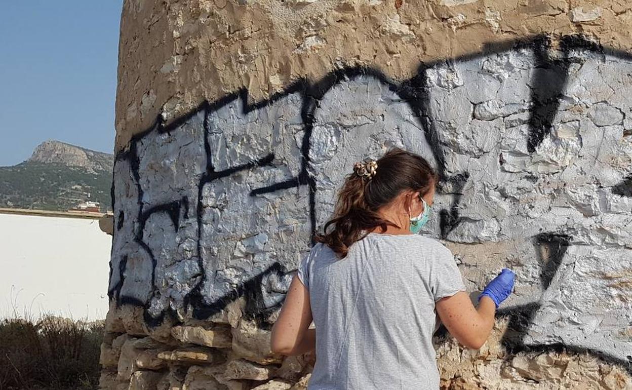 Uno de los operarios durante la limpieza del grafiti.