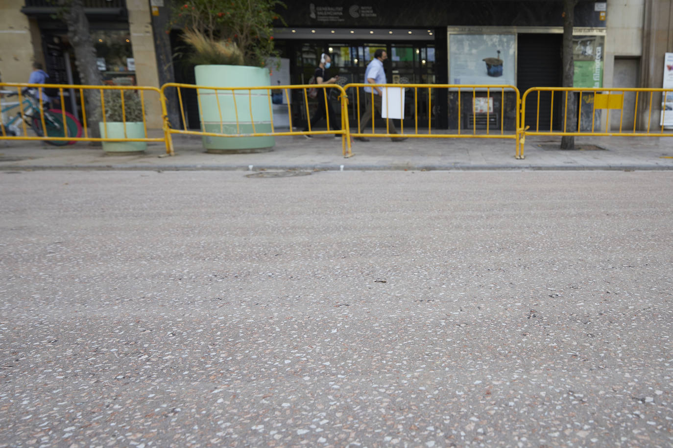 El nuevo asfalto rojizo de la plaza del Ayuntamiento ya está terminado en el tramo frente al teatro Rialto, cerca de la esquina con la calle Barcelonina, por lo que es la imagen más fidedigna de cómo quedará la plaza cuando terminen las obras, que se espera que finalicen en días. 