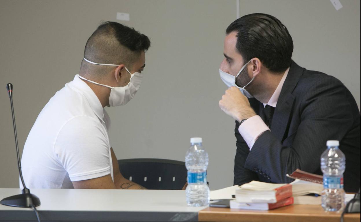 El acusado dialoga con un abogado de la defensa poco antes del arranque del juicio, ayer, en Valencia.