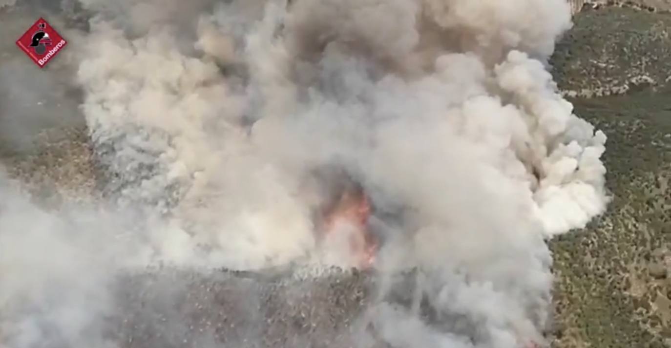 Varias dotaciones de bomberos trabajan para extinguir el fuego que afecta a la localidad alicantina.