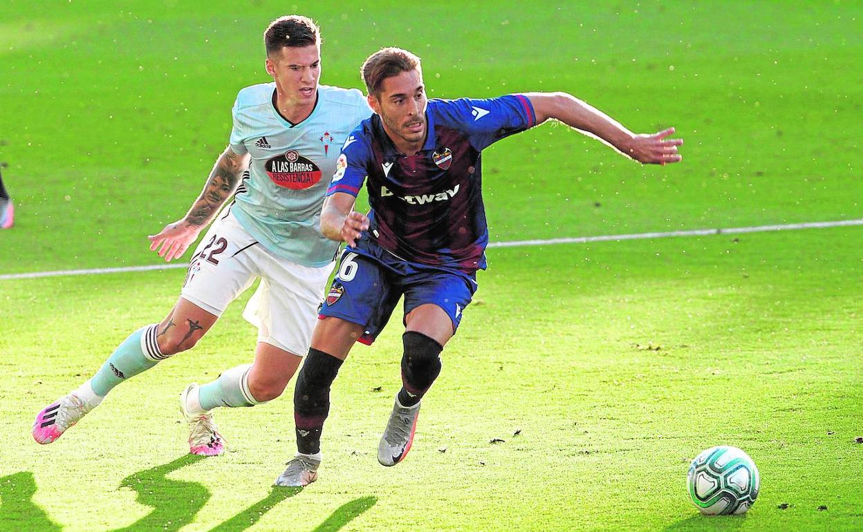 Rochina conduce el balón presionado por Santi Mina. 