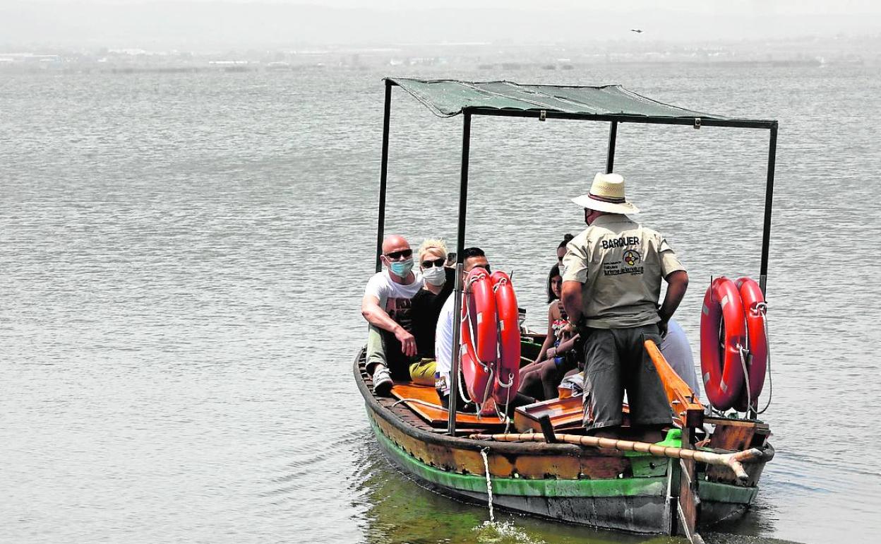 Un grupo de personas pasea en barca por la Albufera.