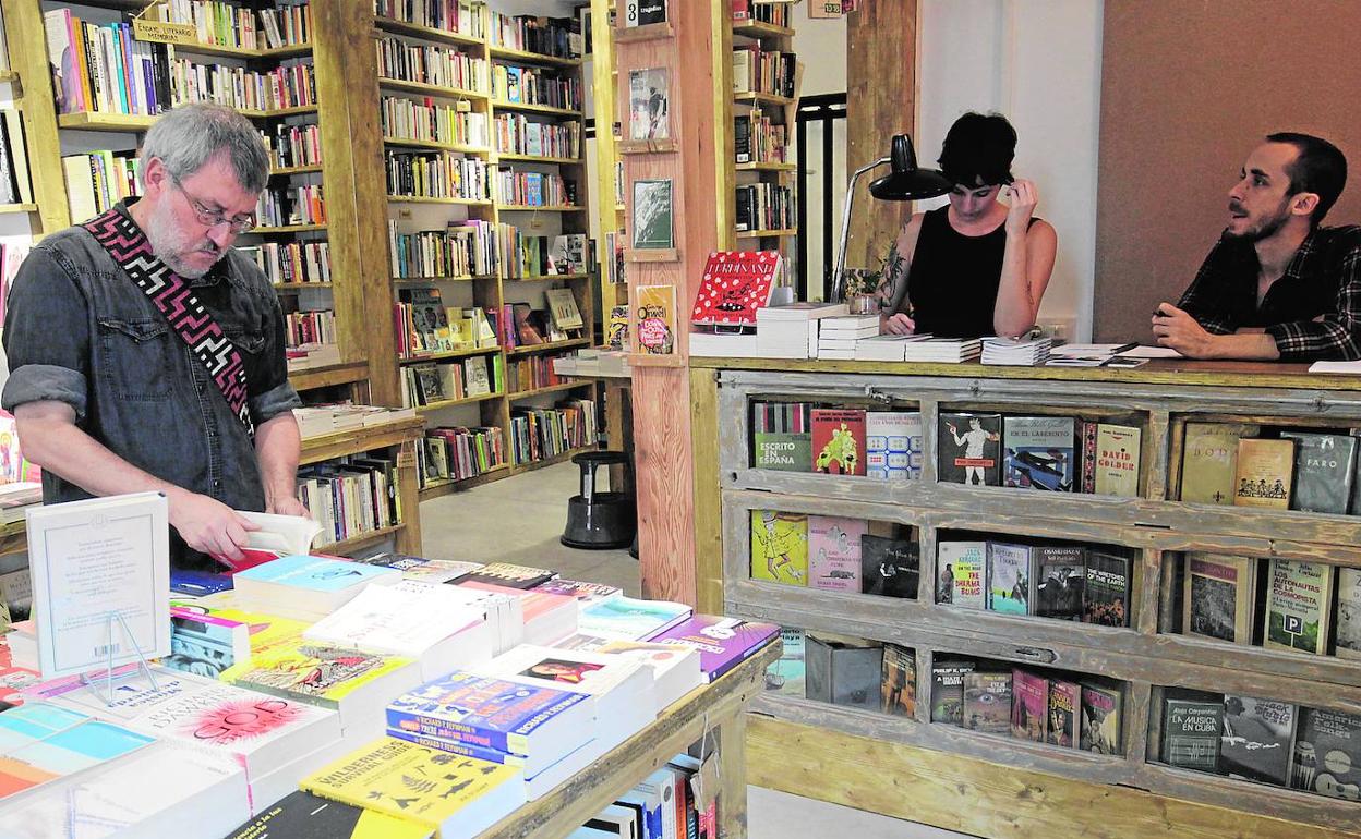 Un hombre consulta volúmenes expuestos en una librería de Valencia. 