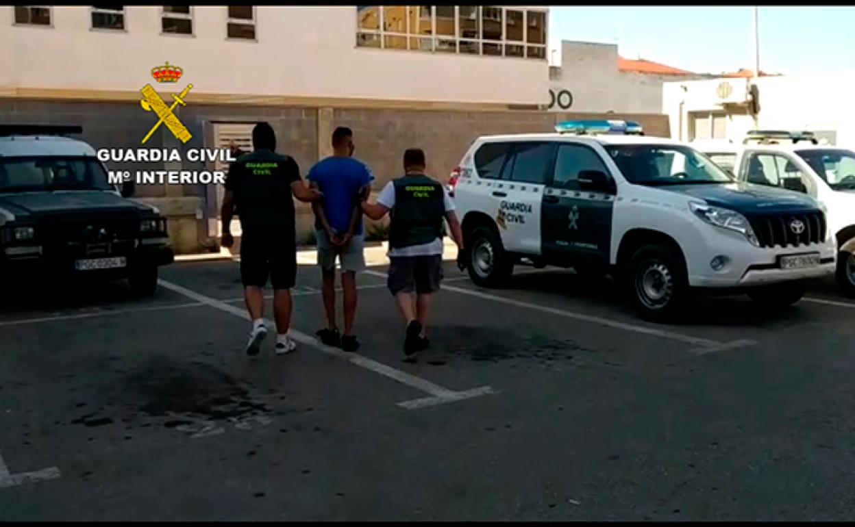 Dos agentes de la Guardia Civil acompañan al turista tras su detención. 