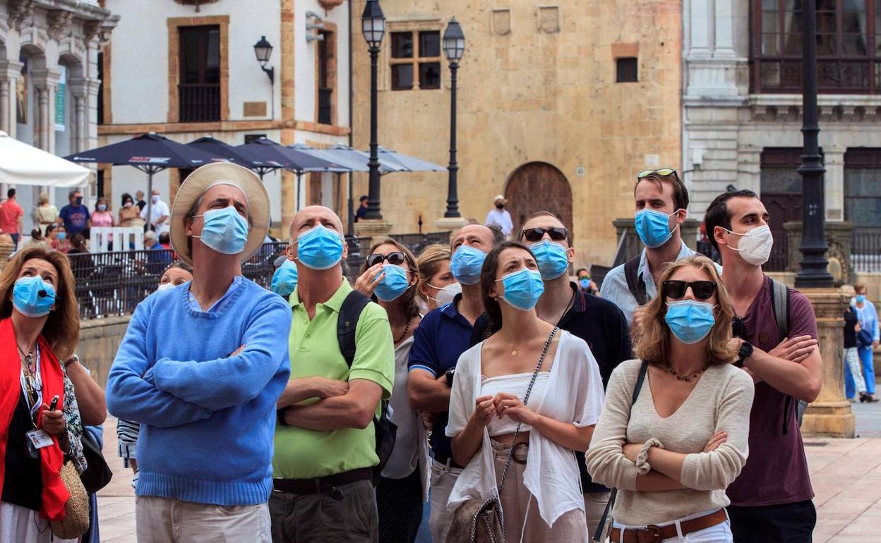 Un grupo de turistas observa la catedral de Oviedo . 