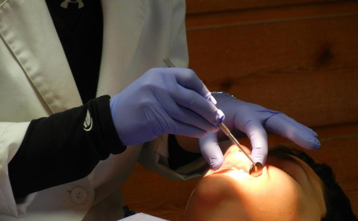 Un dentista revisa a un paciente durante una visita.