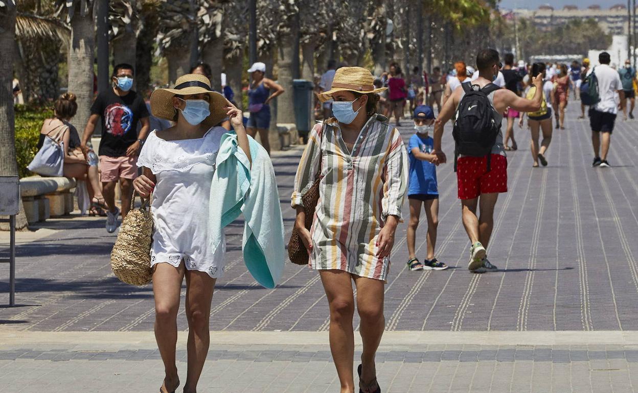 Turistas por el paseo de la playa de las Arenas de Valencia. 