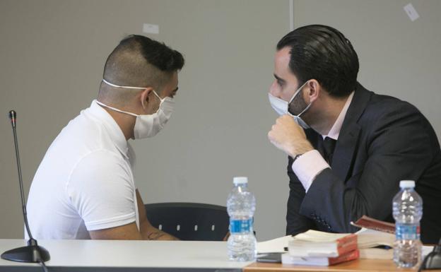 El acusado dialoga con un abogado de la defensa poco antes del arranque del juicio, en Valencia. 