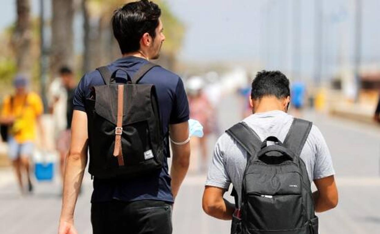 Dos jóvenes en el paseo marítimo de Valencia. 