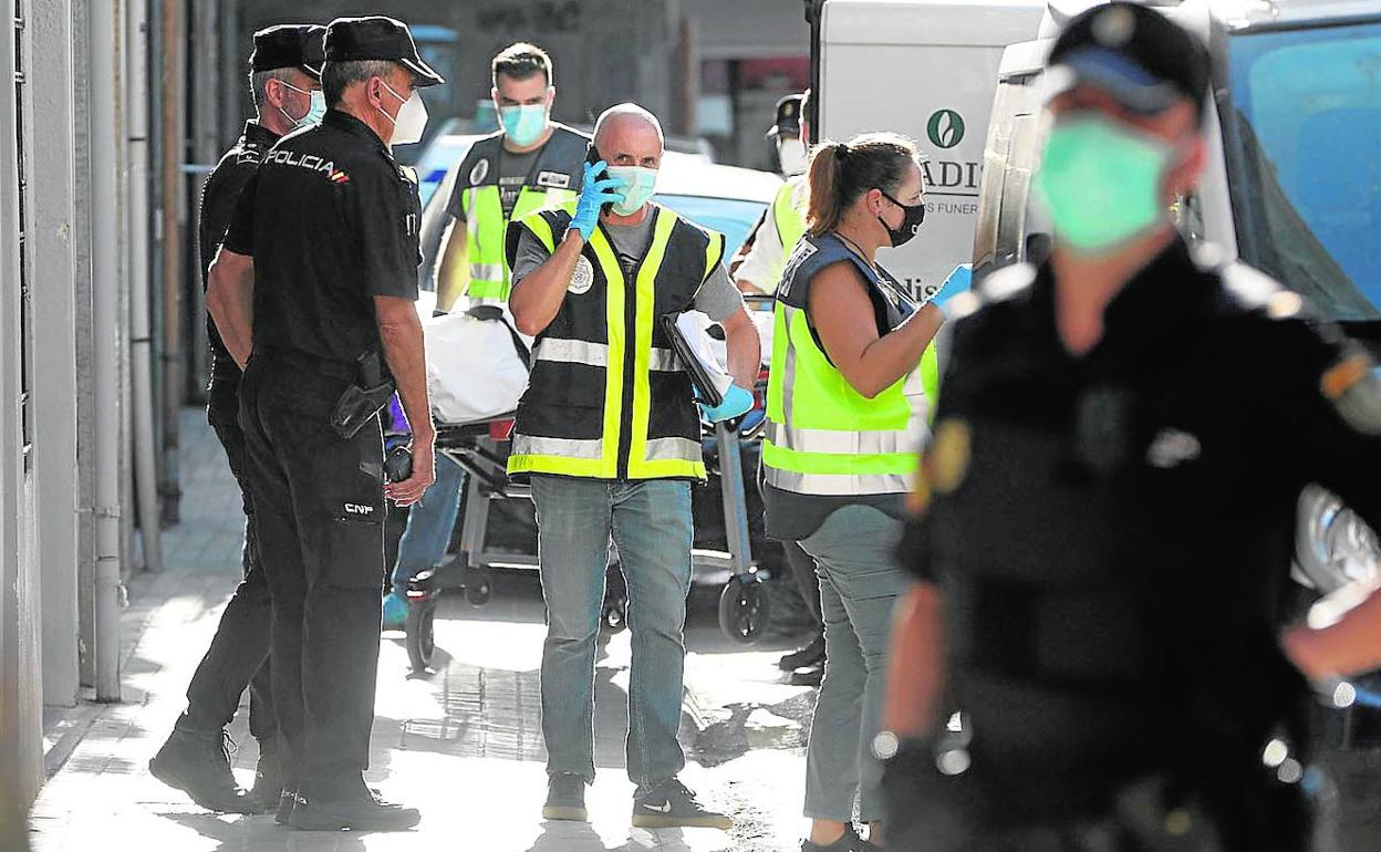 Agentes de la policía transportan el cadáver en el lugar de los hechos. 