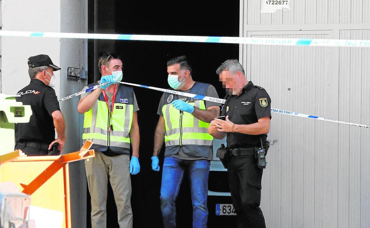 Agentes de la Policía Nacional en la planta baja de la calle Planas donde se produjo el crimen. 