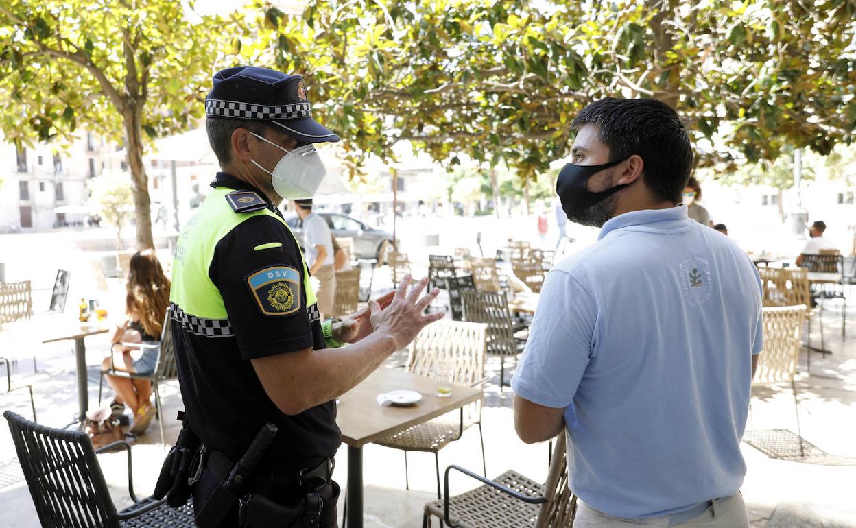 Un policía local informa a un vecino acerca de las nuevas restricciones. 