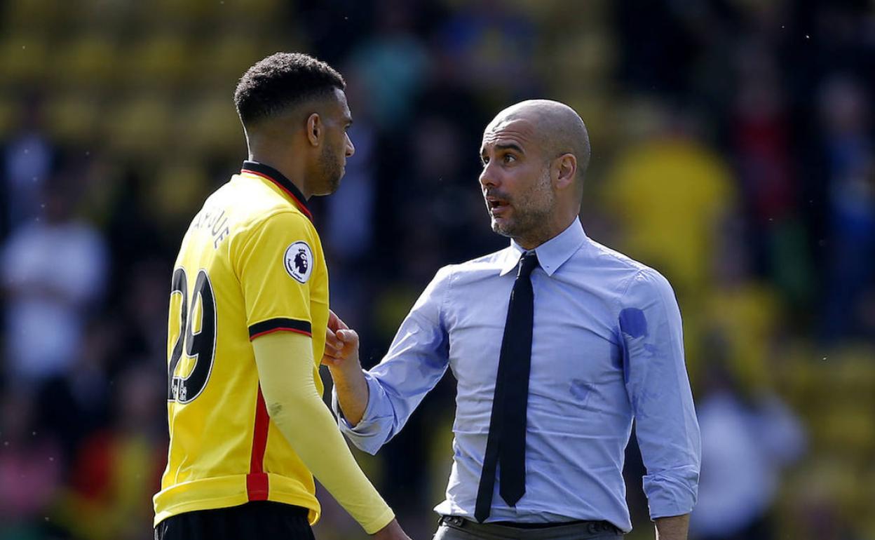 Capoue charla con Guardiola durante un partido en la Premier. 