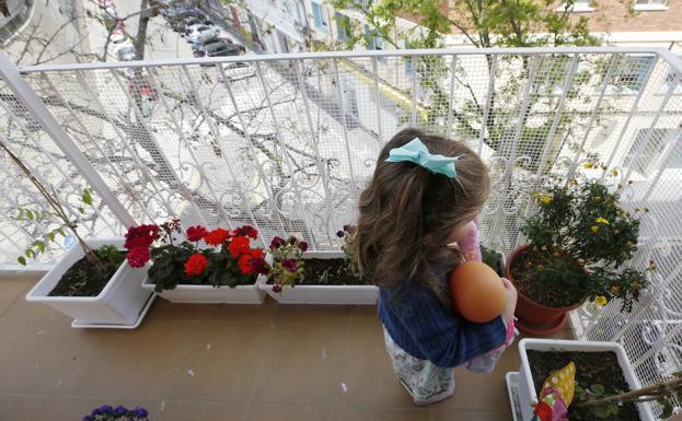 Una niña juega en el balcón de su casa durante el confinamiento por coronavirus.