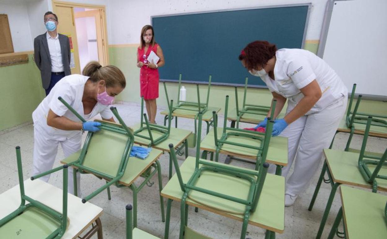 Dos políticos supervisan los trabajos del dispositivo especial de limpieza que se está ultimando en todos los centros educativos. 