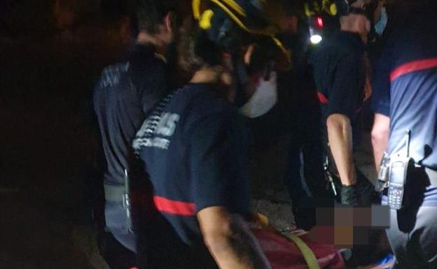 Los bomberos trasladan a la joven a la ambulancia, una vez estabilizada. 