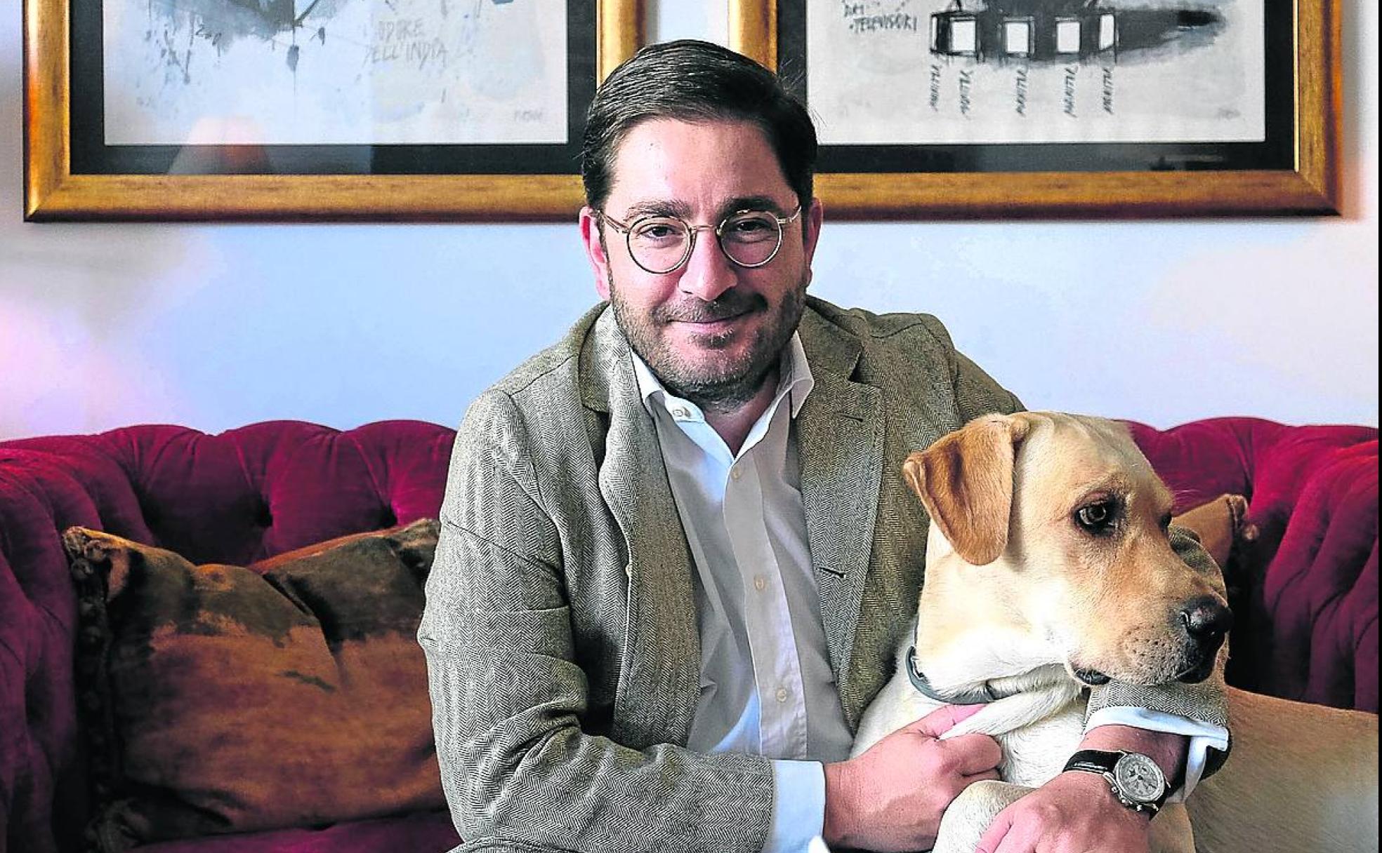 Manuel Muñiz, en su casa de Madrid, con Pepelu, la mascota de la familia.