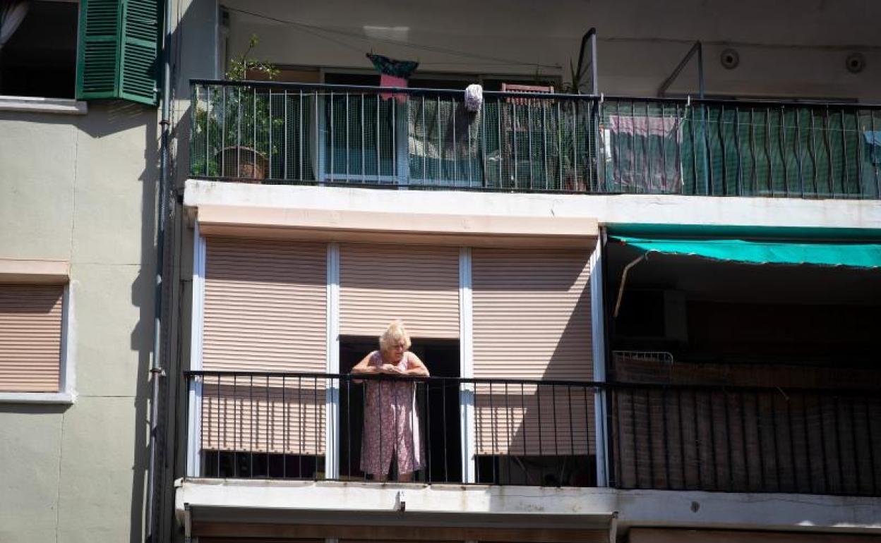 Una mujer se asoma al balcón en el barrio confinado de Son Gotleu, en Palma de Mallorca.