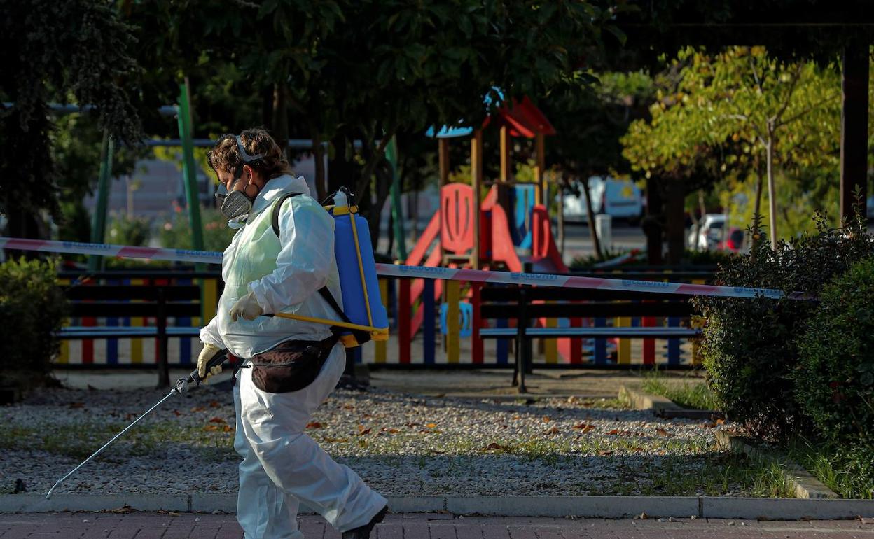 Una trabajadora desinfecta una zona infantil. 