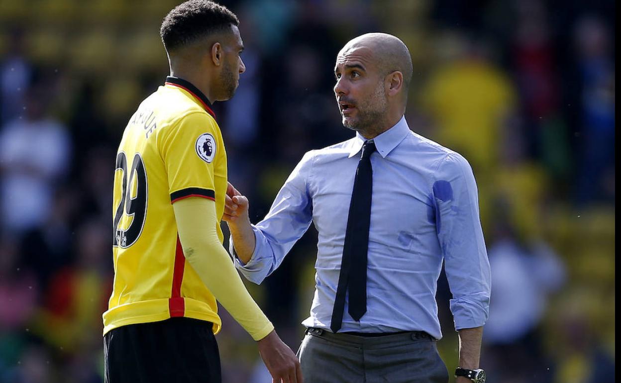 Capoue charla con Guardiola en un partido entre el Watford y el City 