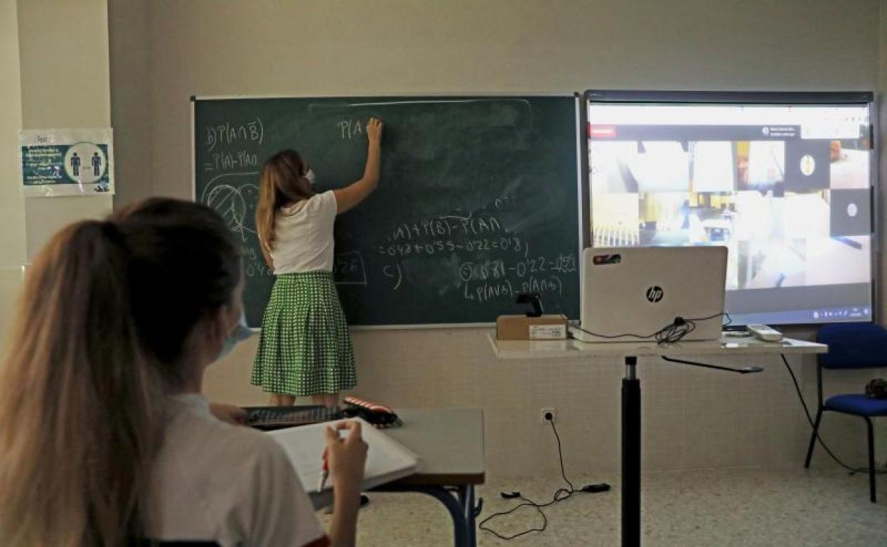 Una profesora explica en clase. 