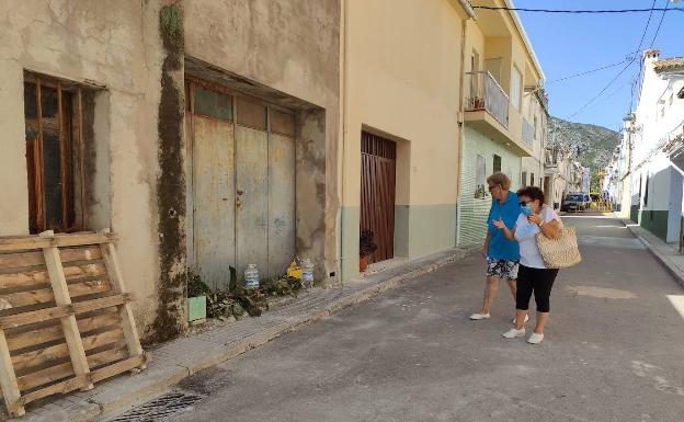 Dos vecinos contemplan las barreras de vegetación puestas en una puerta para evitar que los gatos se cuelen en una vivienda.