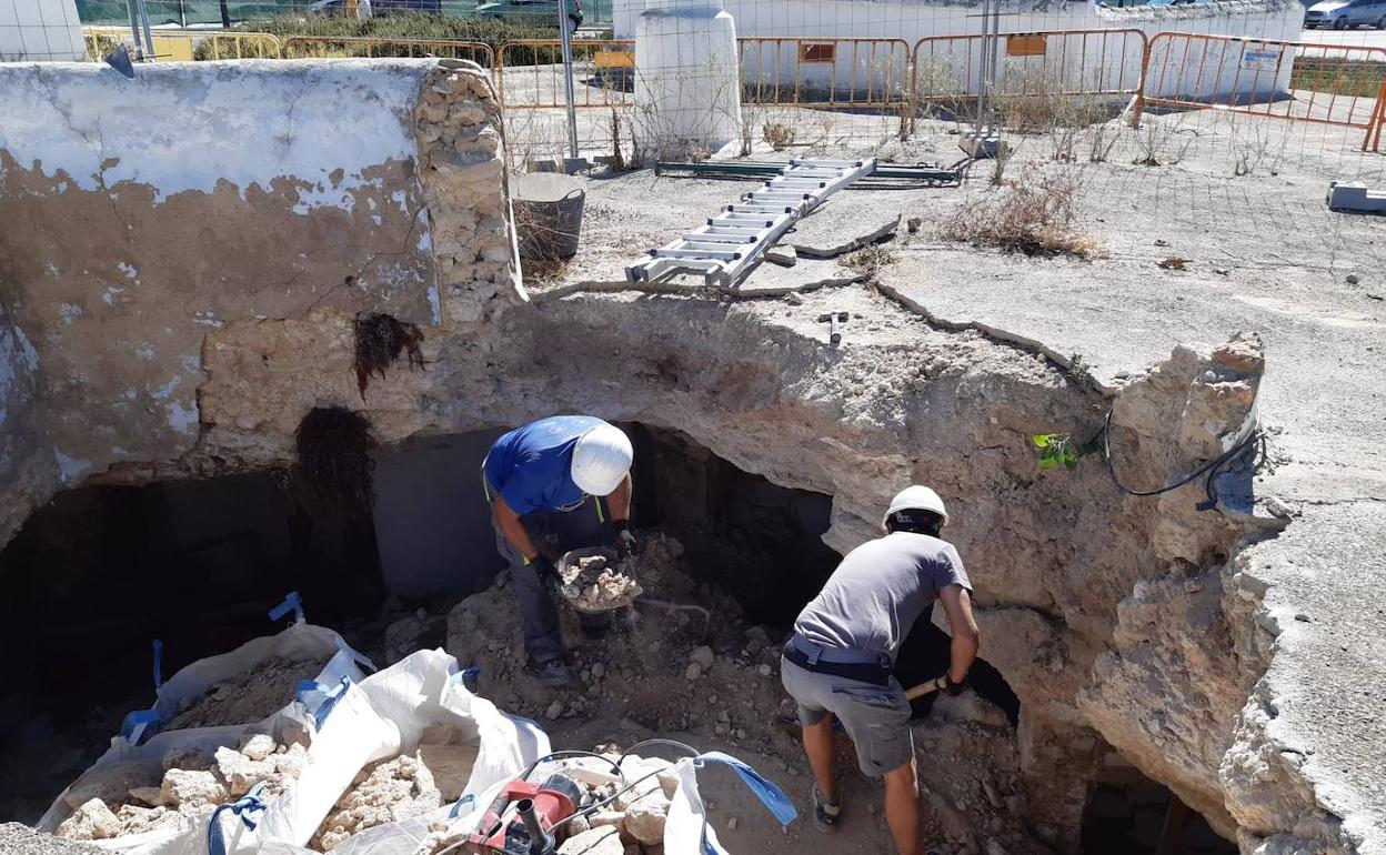 Dos operarios realizan trabajos de desescombro de la cueva derrumbada por las lluvias. 