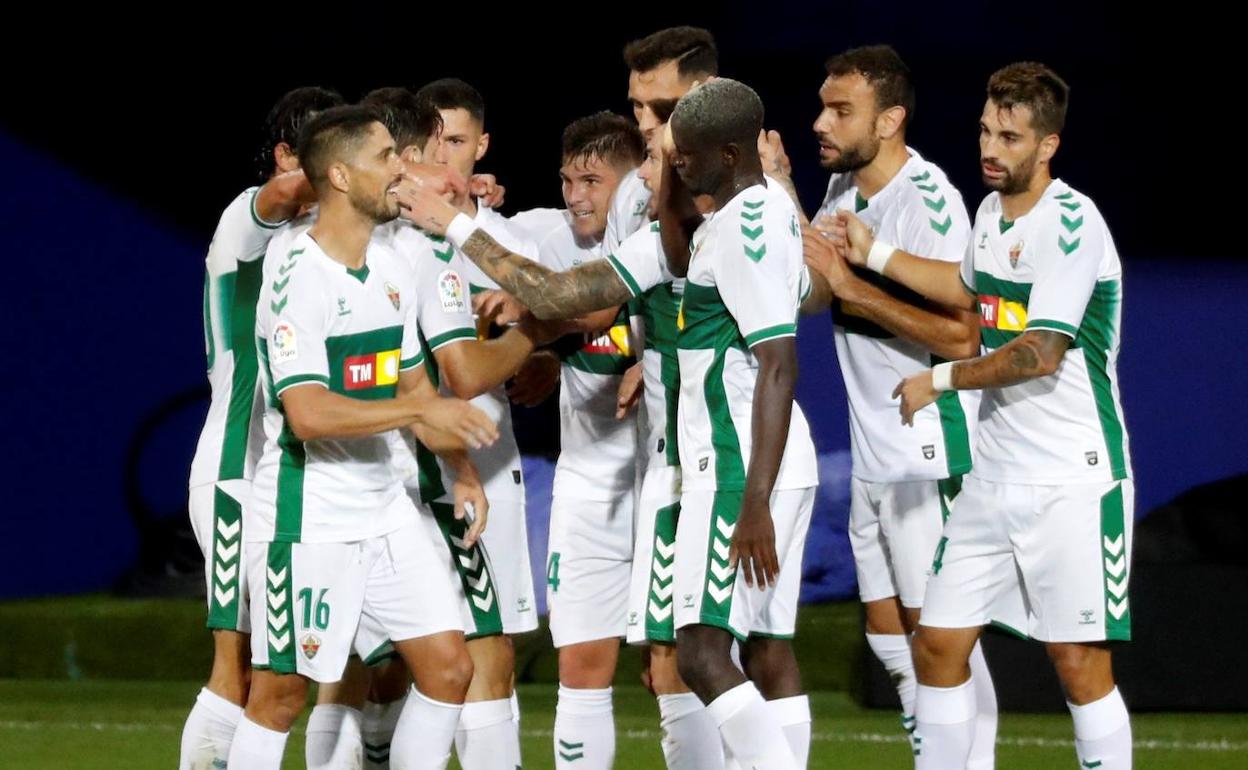 Los jugadores del Elche abrazan al delantero argentino tras el gol de la victoria de anoche. 