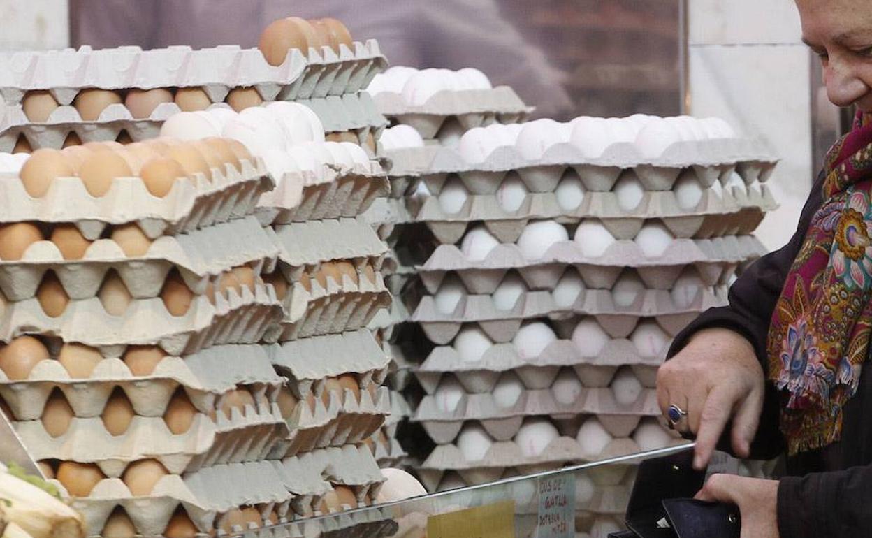 Una mujer compra huevos en un establecimiento. 