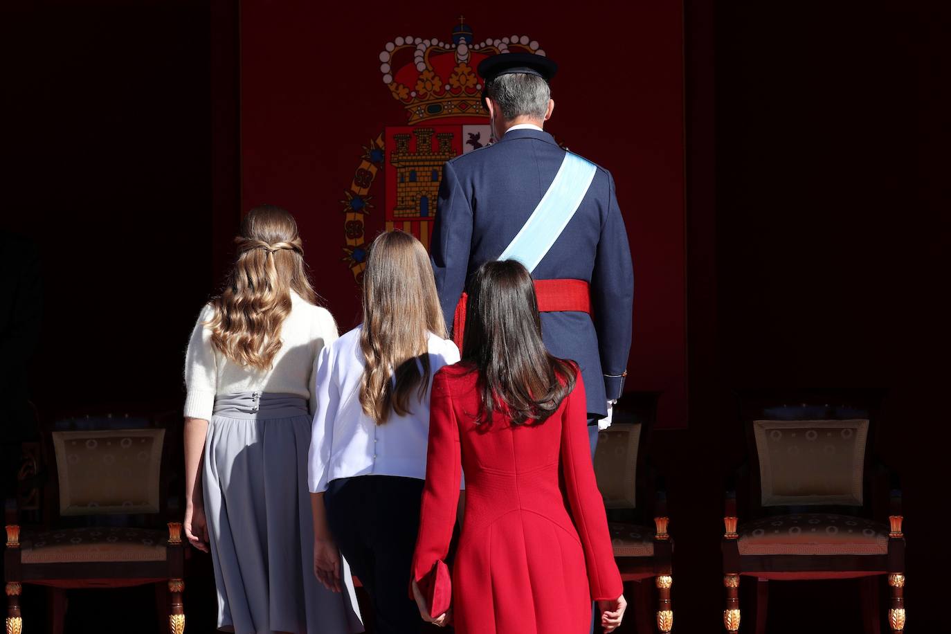 La Reina Letizia, la Princesa Leonor y la Infanta Sofía han sido también protagonistas en el acto de celebración del Día de la Fiesta Nacional, celebrado este lunes en la plaza de la Armería del Palacio Real de Madrid. Doña Letizia ha rescatado un sobrio dos piezas de Felipe Varela que lleva en su ropero desde hace años, formado por un vestido de terciopelo con botones y un abrigo recto en crepe que se abrocha con pequeños lazos. La Princesa Leonor, que a finales de este mes cumplirá 15 años, ha sorprendido con una falda abullonada y un cuerpo con mangas de farol, en tonos pastel. Su hermana, la Infanta Sofía, mucho más sobria, ha estrenado este 12-O un pantalón ancho y una camisola con gran lazada. 