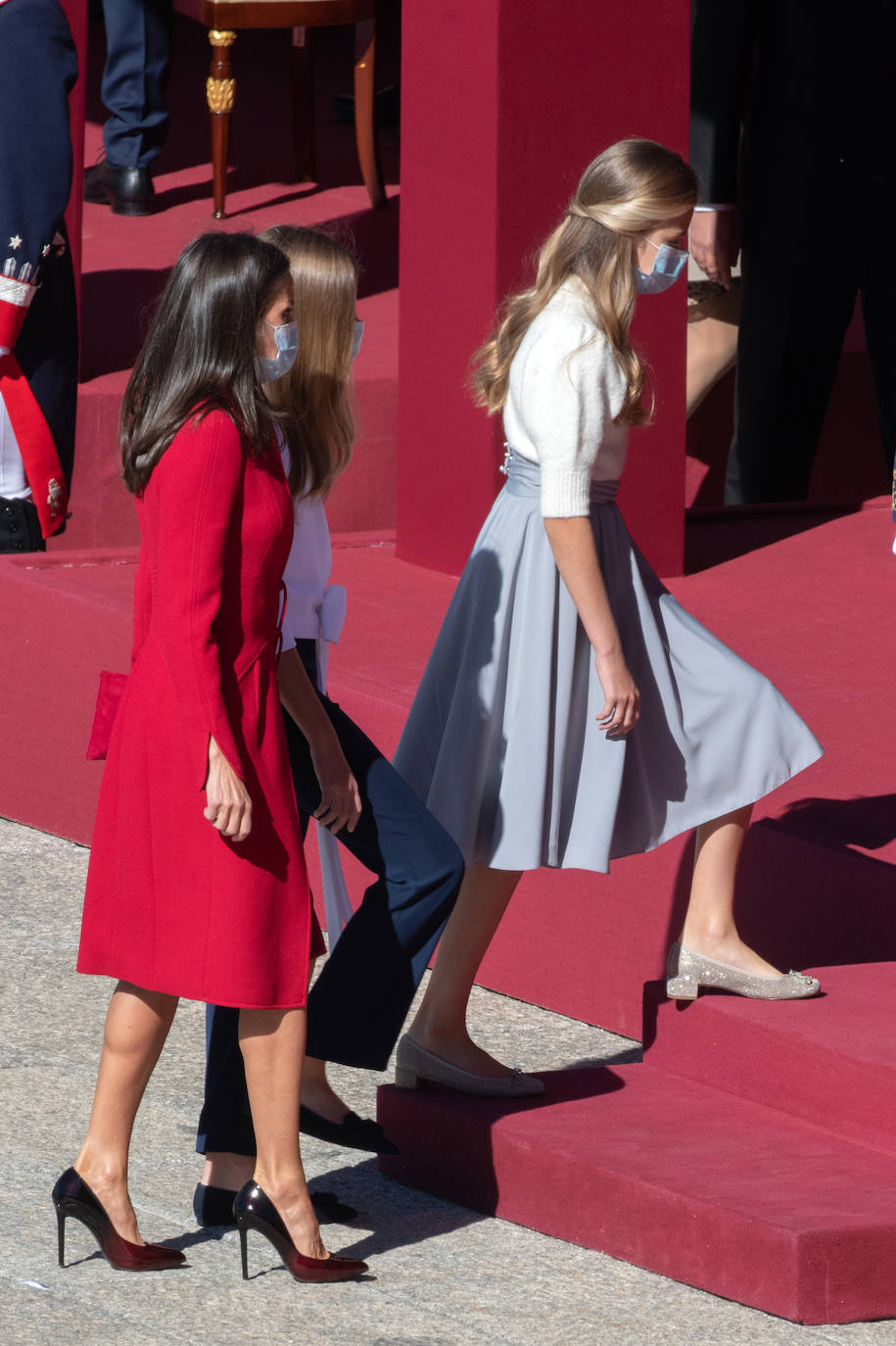 La Reina Letizia, la Princesa Leonor y la Infanta Sofía han sido también protagonistas en el acto de celebración del Día de la Fiesta Nacional, celebrado este lunes en la plaza de la Armería del Palacio Real de Madrid. Doña Letizia ha rescatado un sobrio dos piezas de Felipe Varela que lleva en su ropero desde hace años, formado por un vestido de terciopelo con botones y un abrigo recto en crepe que se abrocha con pequeños lazos. La Princesa Leonor, que a finales de este mes cumplirá 15 años, ha sorprendido con una falda abullonada y un cuerpo con mangas de farol, en tonos pastel. Su hermana, la Infanta Sofía, mucho más sobria, ha estrenado este 12-O un pantalón ancho y una camisola con gran lazada. 