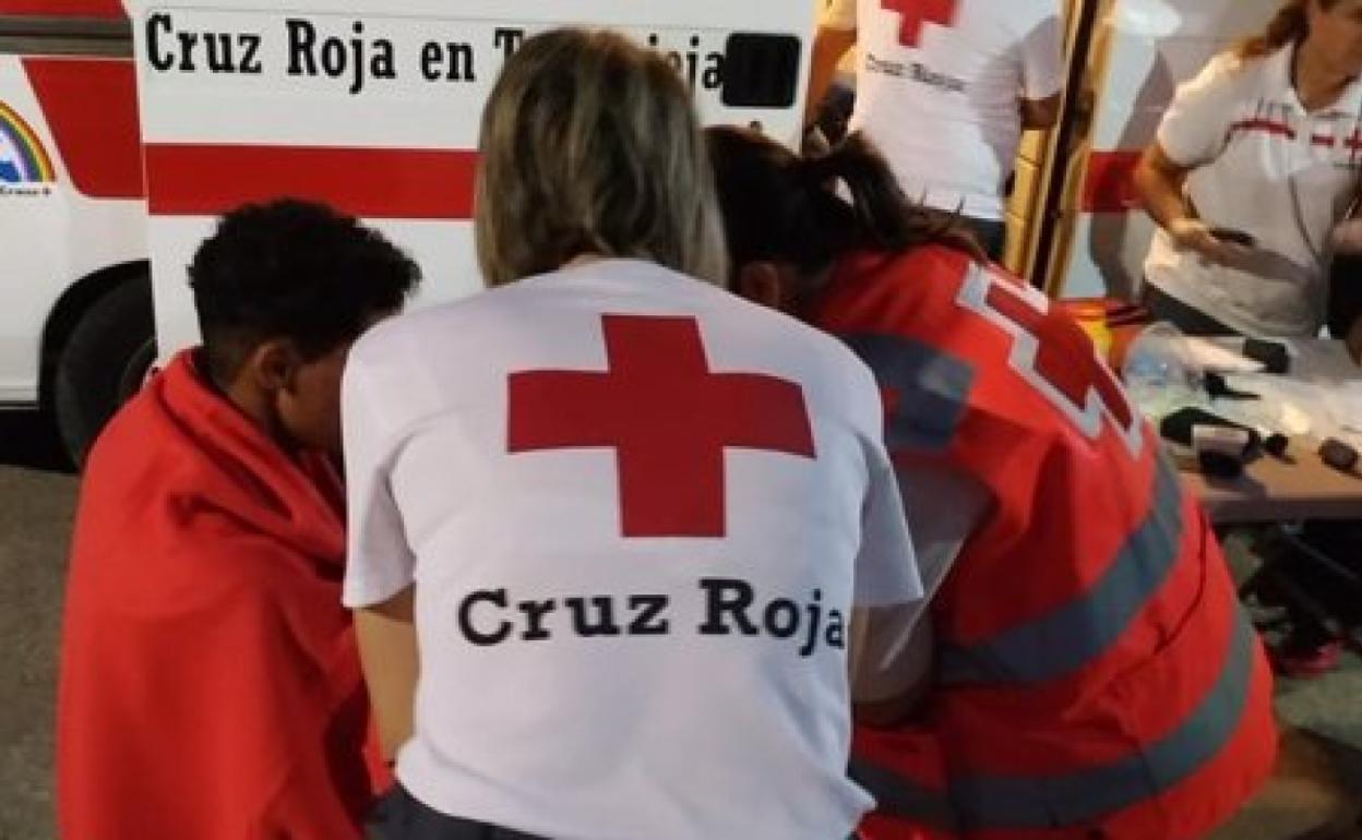Miembros de Cruz Roja atienden a inmigrantes a su llegada al puerto. 