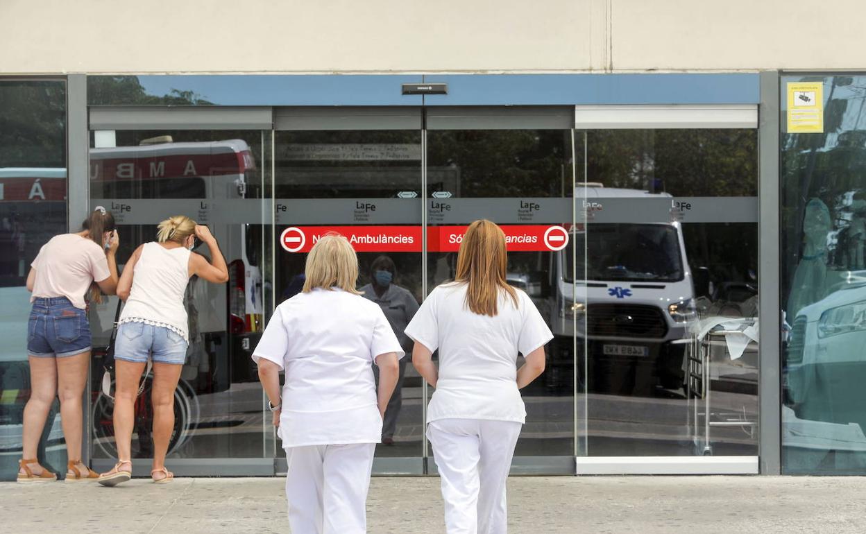 Personal sanitario se dirige a uno de los accesos del hospital La Fe de Valencia.