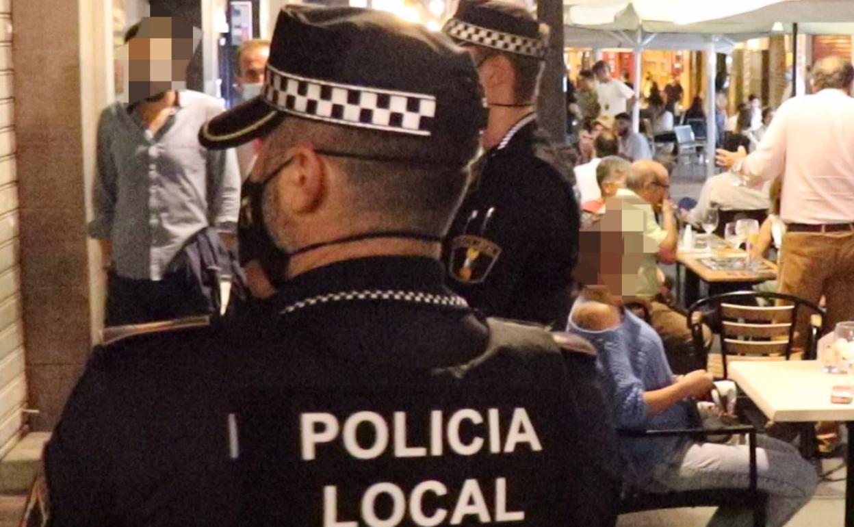 Dos agentes vigilan una de las principales calles peatonales de Alicante. 