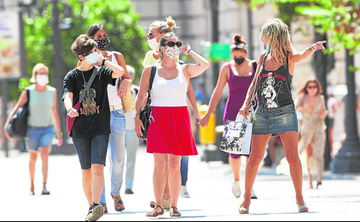 Un grupo de personas pasea por la calle.