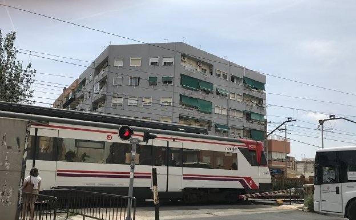 El tren pasa por el paso a nivel de Alfafar. 