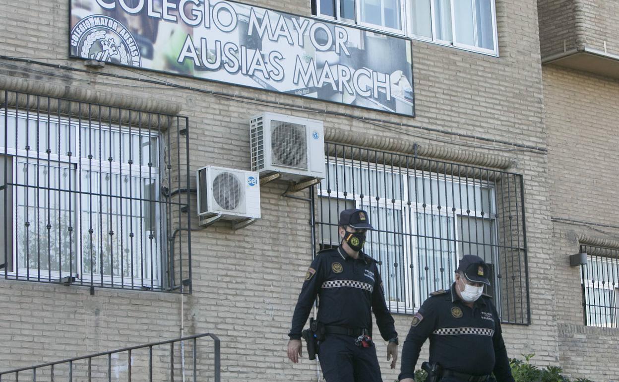 Dos agentes de la Policía Local salen del colegio mayor Ausias March de Valencia.