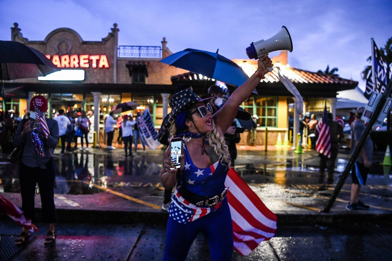 Los partidarios de Trump sostienen carteles y banderas durante una protesta en Miami, Florida, el 5 de noviembre de 2020. - El retador presidencial demócrata Joe Biden el jueves se acercó al número mágico de 270 votos electorales necesarios para ganar la Casa Blanca, pero varios estados de batalla todavía estaban en jugar, mientras el presidente en funciones, Donald Trump, gritó falta sobre el conteo de votos en curso.