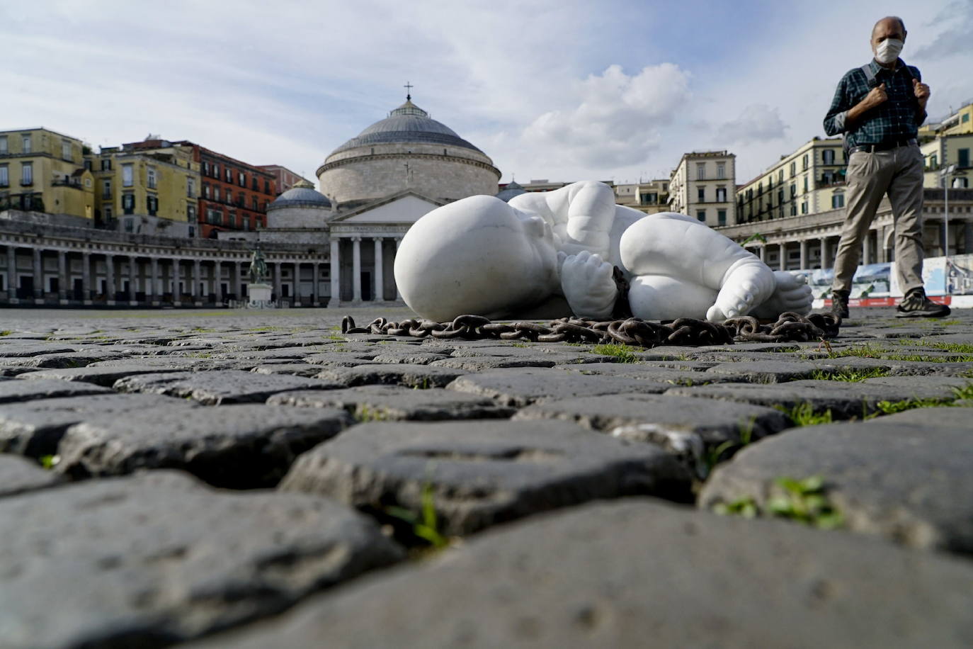 Una escultura en mármol blanco, que representa a un niño acurrucado y con una muñeca encadenada, ha sido abandonada en el centro de la plaza Plebiscito, en Nápoles. 