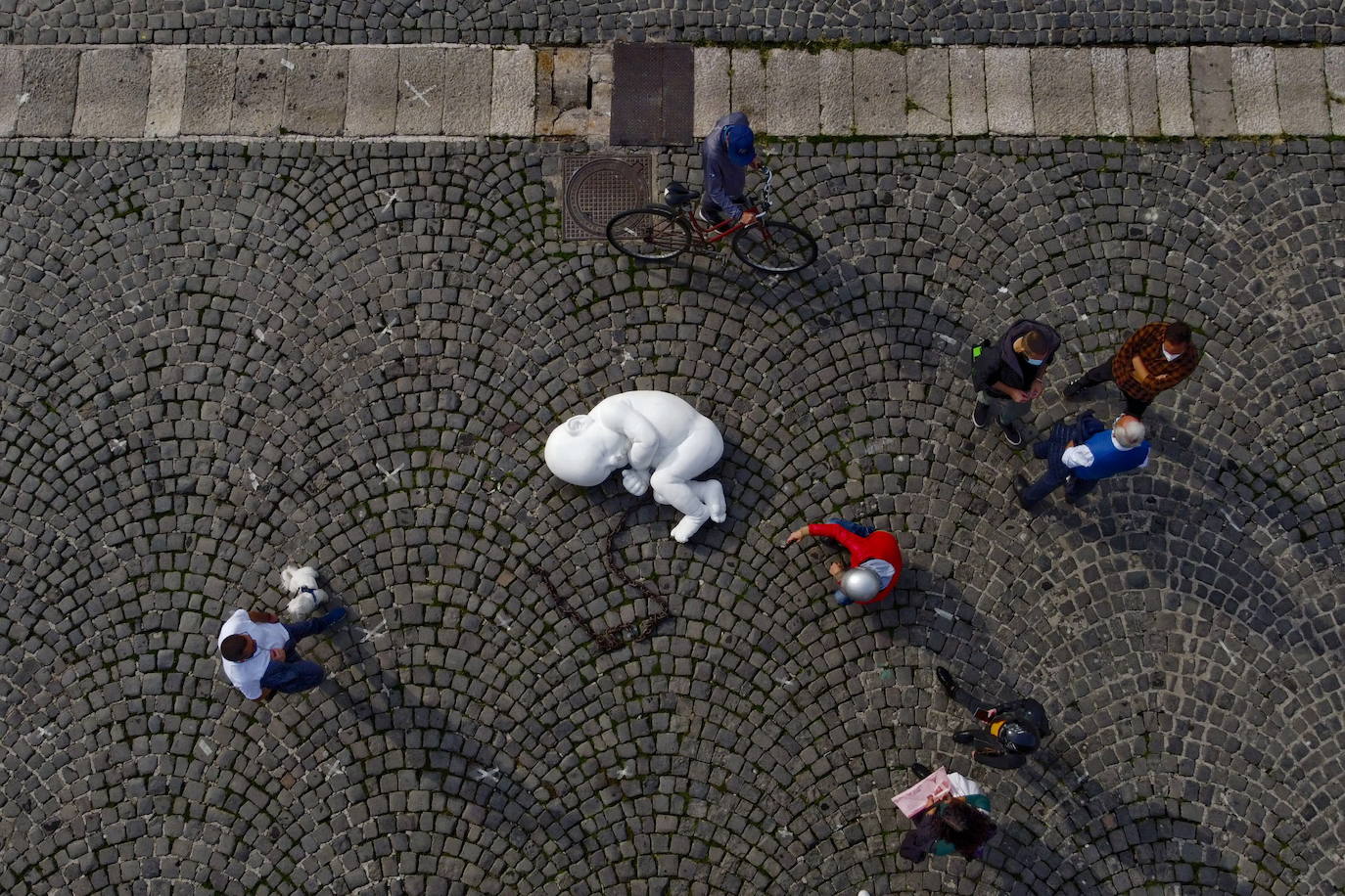 Una escultura en mármol blanco, que representa a un niño acurrucado y con una muñeca encadenada, ha sido abandonada en el centro de la plaza Plebiscito, en Nápoles. 