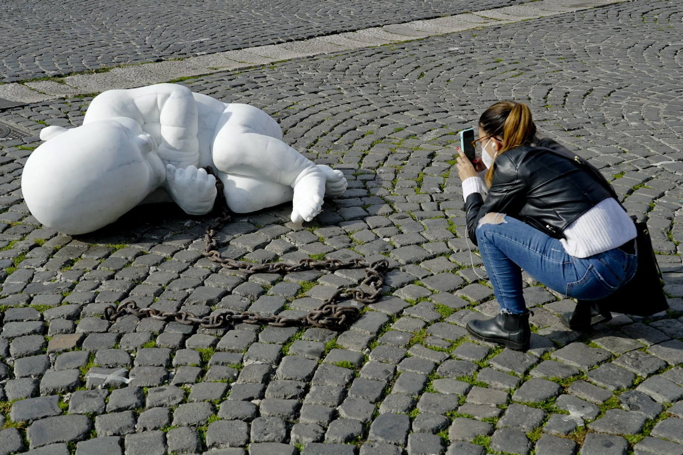 Una escultura en mármol blanco, que representa a un niño acurrucado y con una muñeca encadenada, ha sido abandonada en el centro de la plaza Plebiscito, en Nápoles. 