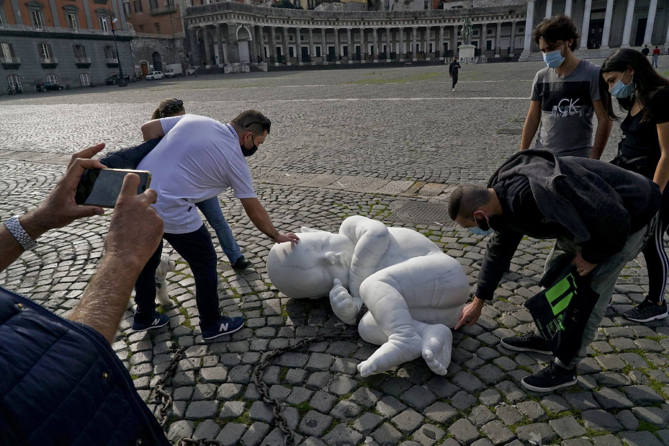 Una escultura en mármol blanco, que representa a un niño acurrucado y con una muñeca encadenada, ha sido abandonada en el centro de la plaza Plebiscito, en Nápoles. 