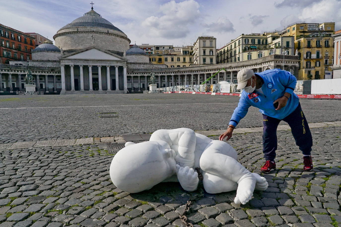 Una escultura en mármol blanco, que representa a un niño acurrucado y con una muñeca encadenada, ha sido abandonada en el centro de la plaza Plebiscito, en Nápoles. 