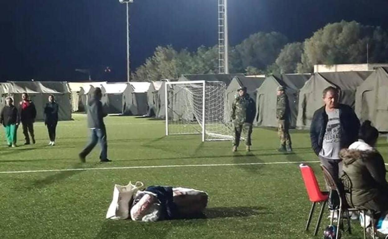 Tiendas de campaña instaladas sobre el césped artificial de la escuela. 